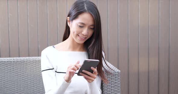 Woman use of cellphone at outdoor coffee shop alt