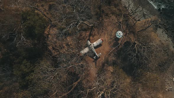 Establishing shot of abandoned small airplane stuck on the top of a hill by the coast in Costa Rica, alt