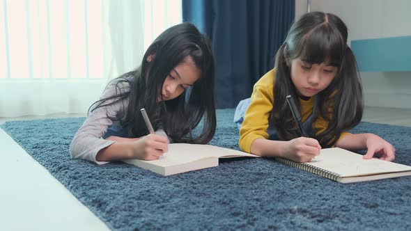 young asian daughter sibling child happiness lay down study online e-learning alt