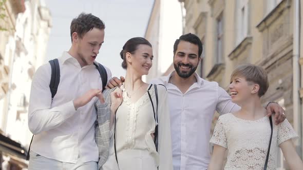 Happy Young People Walking Along City Street alt
