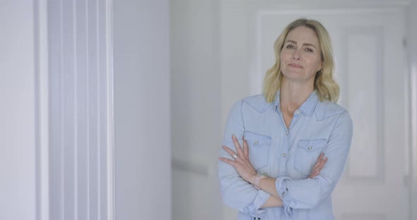 Successful businesswoman standing in home with arms crosses