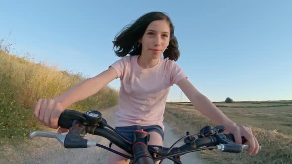 POV of a young girl enjoying a bicycle ride on the rural countryside alt