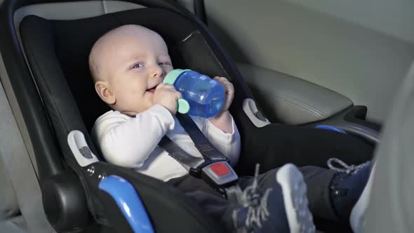 Baby Drinking Water in Car Seat alt
