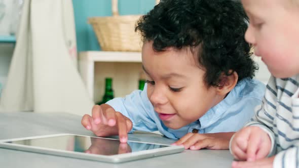 African and Caucasian Little Boys Playing on Digital Tablet