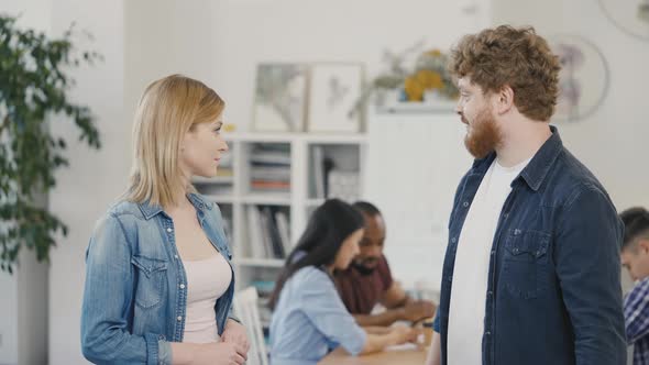Portrait of a Successful Young Man and Woman Giving High Five During a Corporate Meeting Against the alt