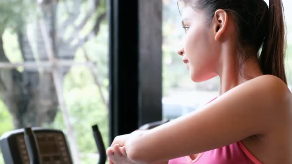 Young pretty Asian sport girl stretching her body and arm in health gym or fitness after exercise. alt
