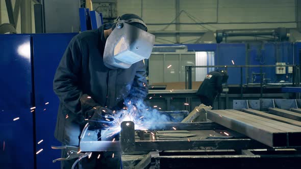 Welding Technician Is Brazing Pieces of Metal. Professional Welder Working at Factory Facility. alt