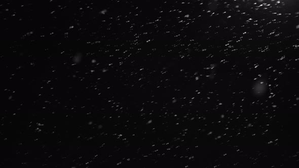 Snow Falling Over Black Background or Night Sky alt