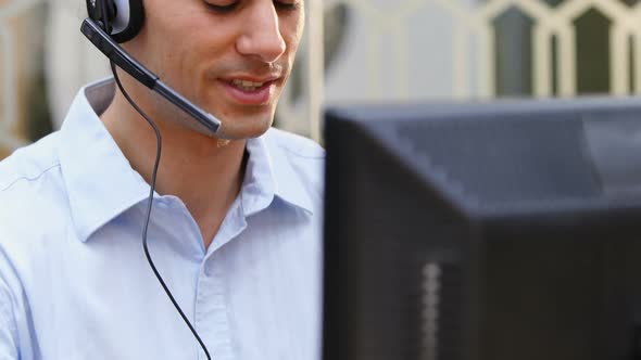 Smiling customer service executive talking on headset at desk 4k alt