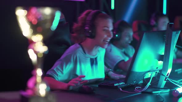 Handheld Female Gamers in Headphones Plays a Video Game Cyber Sportsmans at the Game Communication alt