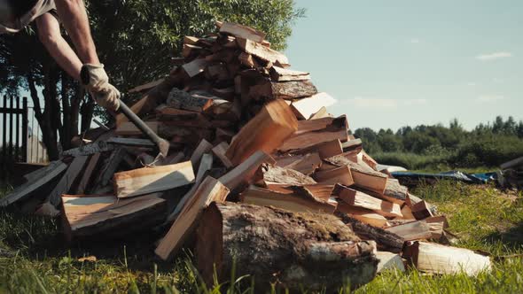 Strong Male Worker Chopping Wood Swinging and Hitting Wooden Log with Axe alt