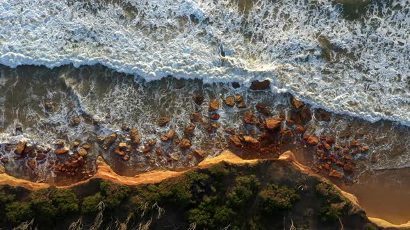 AERIAL DIRECTLY ABOVE Limestone Cliff, Waves Crashing, Coastal Erosion alt