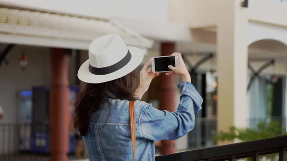 Young Asian woman using smartphones take photos around community malls.