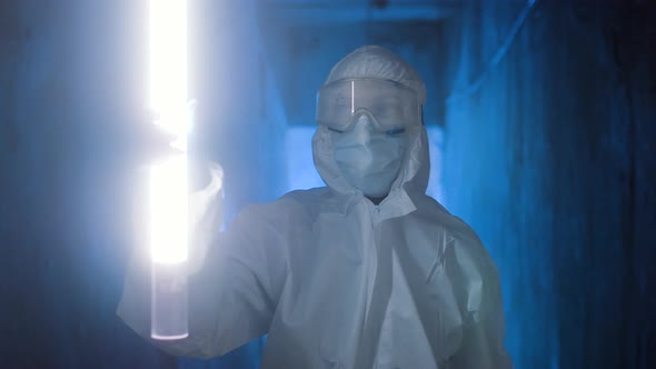 Hazmat Suit Wearing Woman Explores a Dark Tunnel alt