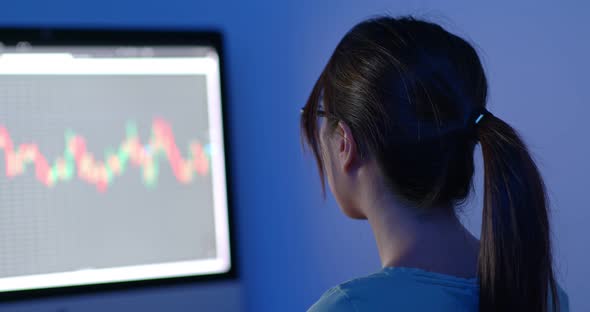 Woman work on stock photo market graph at night alt