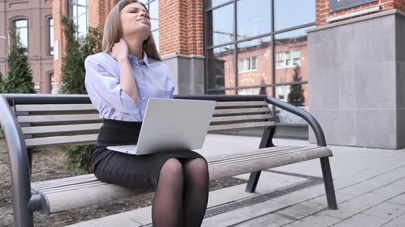 Tired Young Woman Sitting Outside Office Working on Laptop alt