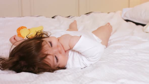 Cute baby girl playing on bed alt