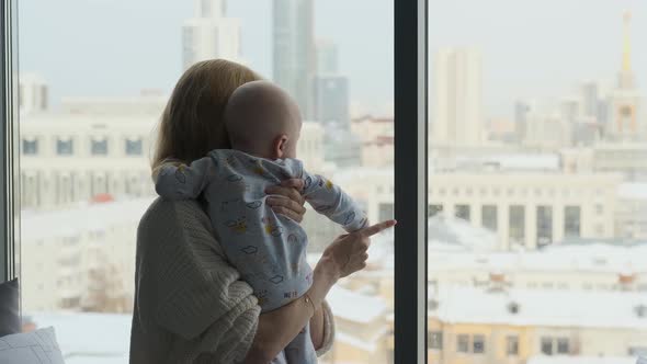 woman with child look out the window at home