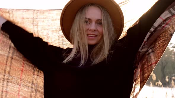 Caucasian Blonde Woman with Beige Hat Wearing Scarf Playing with Sunbeam in the Countryside alt