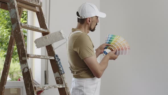 house painter man decorator choose the color using the sample swatch