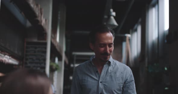 Waiter walking to the table checking on dinner guests alt