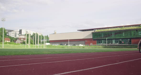 A Female Person with Disabilities Riding a Wheelchair on a Training Track