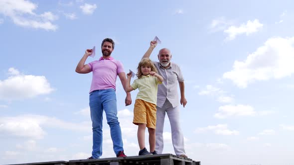 Happy Family of Boy Child with Father and Grandfather Hold Paper Planes Skyhigh Leisure alt