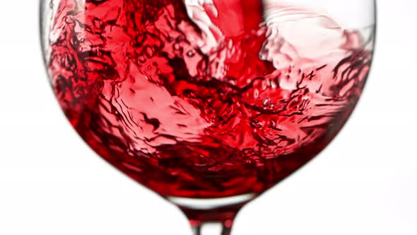 Super Slow Motion Detail Shot of Pouring Red Wine Isolated on White Background at 1000Fps alt