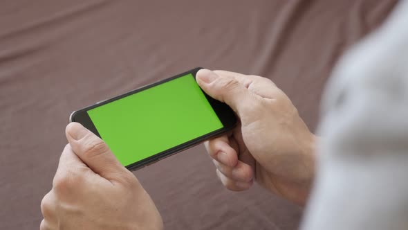 Internet surfing on   greenscreen smart phone  4K 2160p 30fps UltraHD footage - Male hands hold mode alt