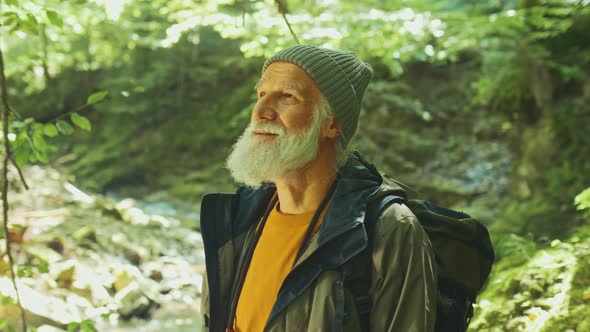 Happy Elderly Man with a Backpack and Nordic Walking Sticks Active Retirement alt