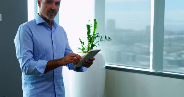 Male executive using digital tablet in office alt