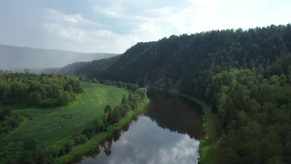 Aerial View of Beautiful River Among Green Forest and Meadow