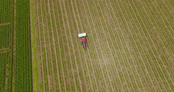 Fertilizer spreader in a large field, Aerial follow footage. alt