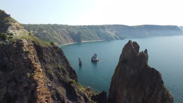 Aerial View From Above on Calm Azure Sea and Volcanic Rocky Shores alt