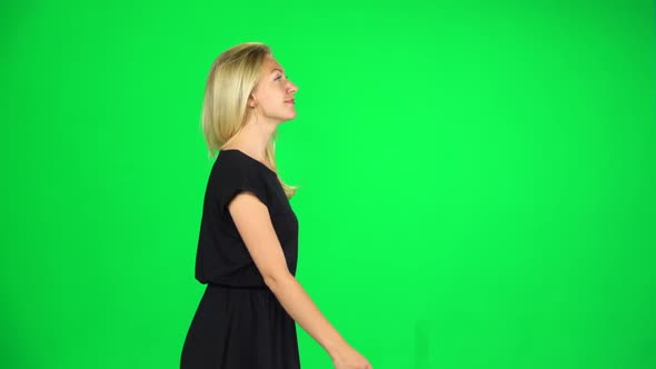 Contented Girl Is Walking and Waving a Hand Welcoming. Chroma Key. Slow Motion. Side View alt