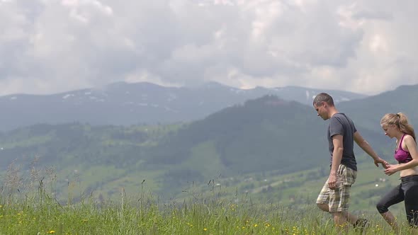 Young Couple Man and Woman Jogging Outdoors in Summer Mountains alt