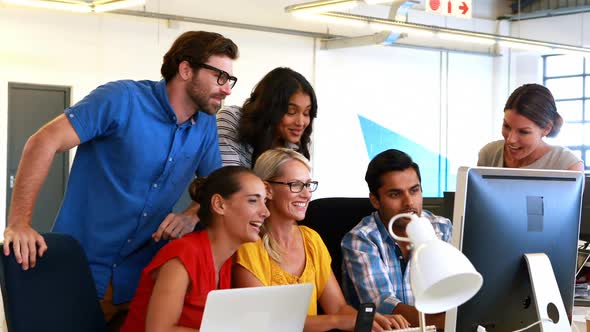 Businesspeople having a discussion while using computer alt