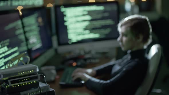 Female Hacker Writing Computer Code in Dark Office alt