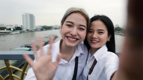 Happy Asian lesbian couples using smartphone video chatting with friends travel in Thailand.