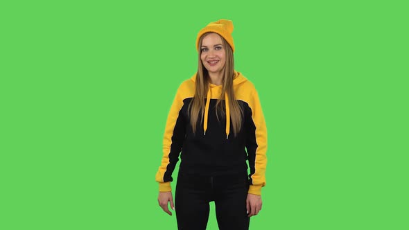 Modern Girl in Yellow Hat Is Making Sign Ok. Green Screen alt