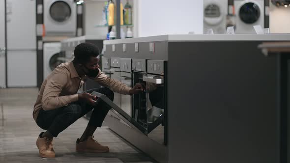 Black Man with Face Mask is Viewing Electric Oven in Home Appliances Store Afro American Man is alt