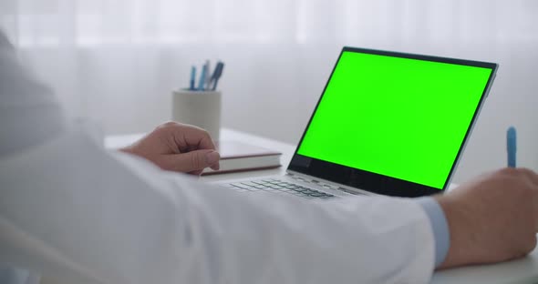 Doctor Is Listening Patient at Online Consultation By Video Call and Writing Notes, Laptop with alt