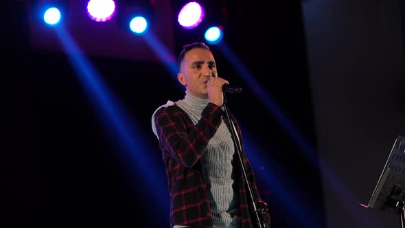 The Vocalist Sings Into the Microphone at the Concert alt