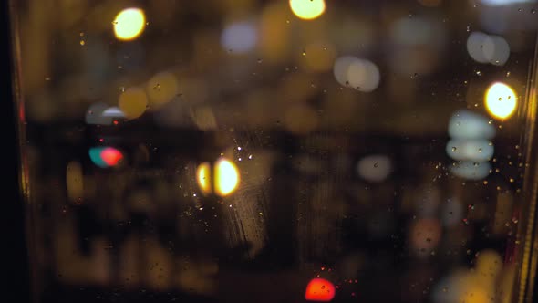 Raindrops on a window at night alt