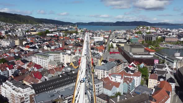 Moving forward along the boom of construction crane - Beautiful Bergen city aerial view in backgroun alt