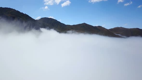 Peak of Foggy Green Mountains and Cloudscape under Blue Sky