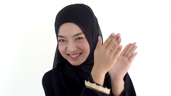 Portrait beautiful Muslim woman wearing traditional clothing clapping hands
