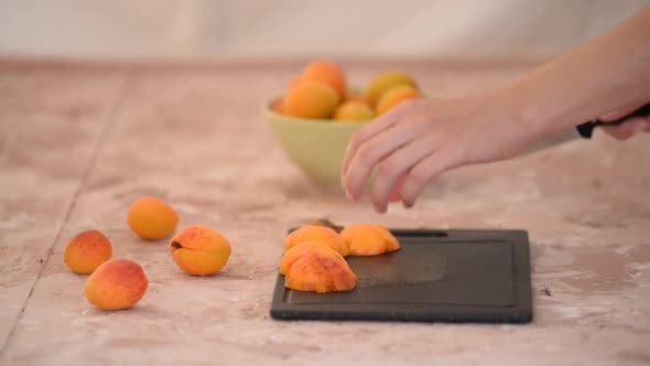 Female Hands Cutting Fresh Sweet Apricot