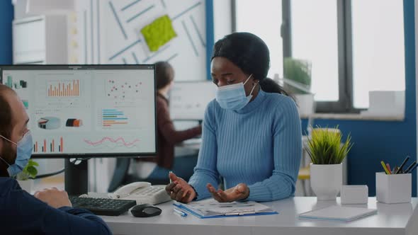 Diverse Business People with Face Mask Talking About Financial Strategy alt