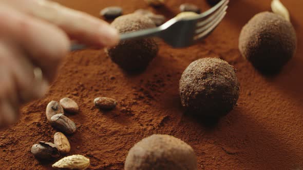 Closeup Confectioner Hand Cutting Truffle Chocolate By Fork in Slow Motion. alt